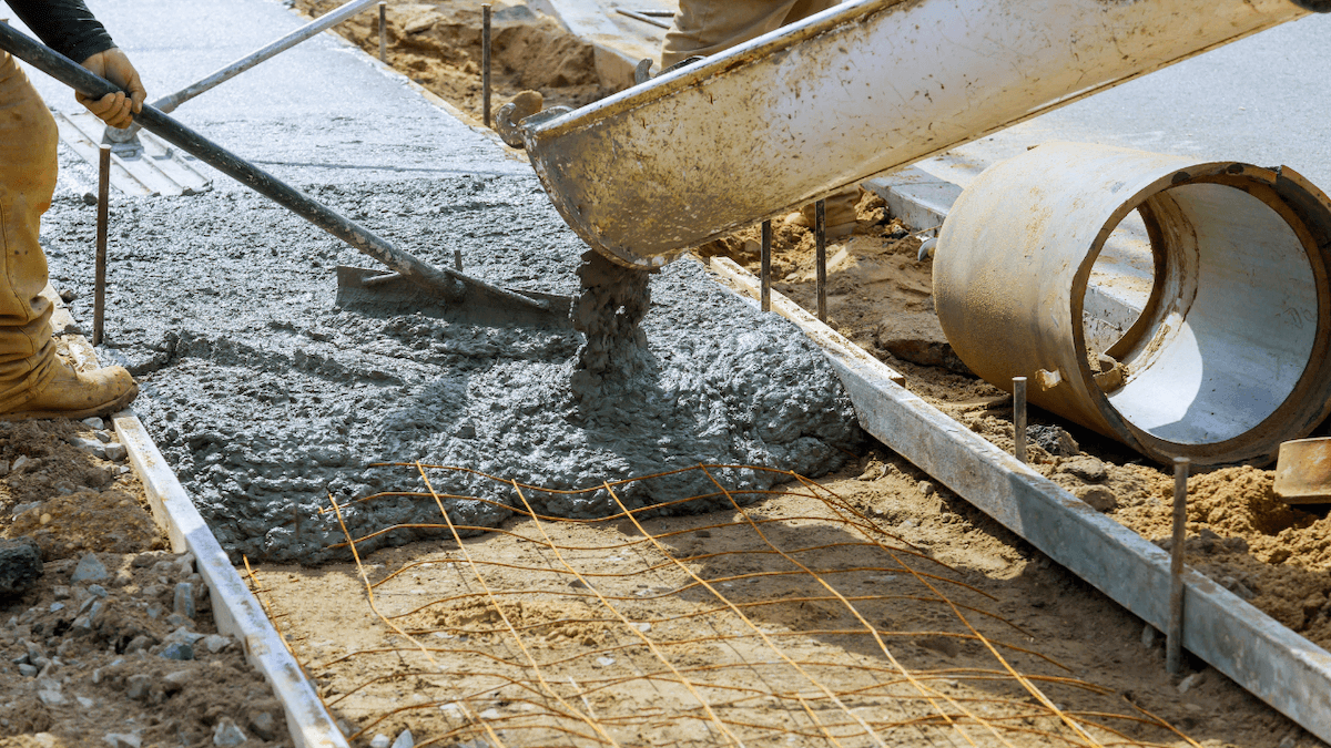 concrete batch plant pouring concrete into a mold to make a road